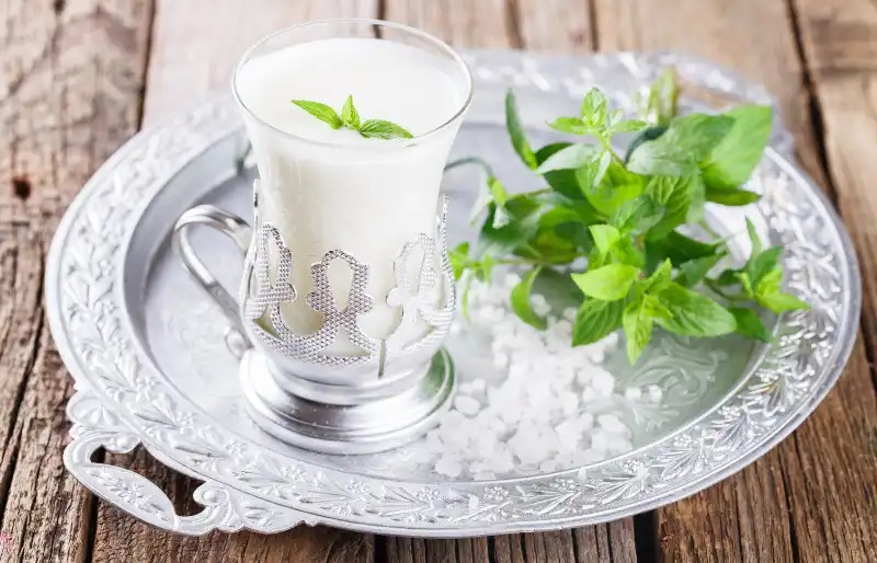 A glass of buttermilk in a silver tray
